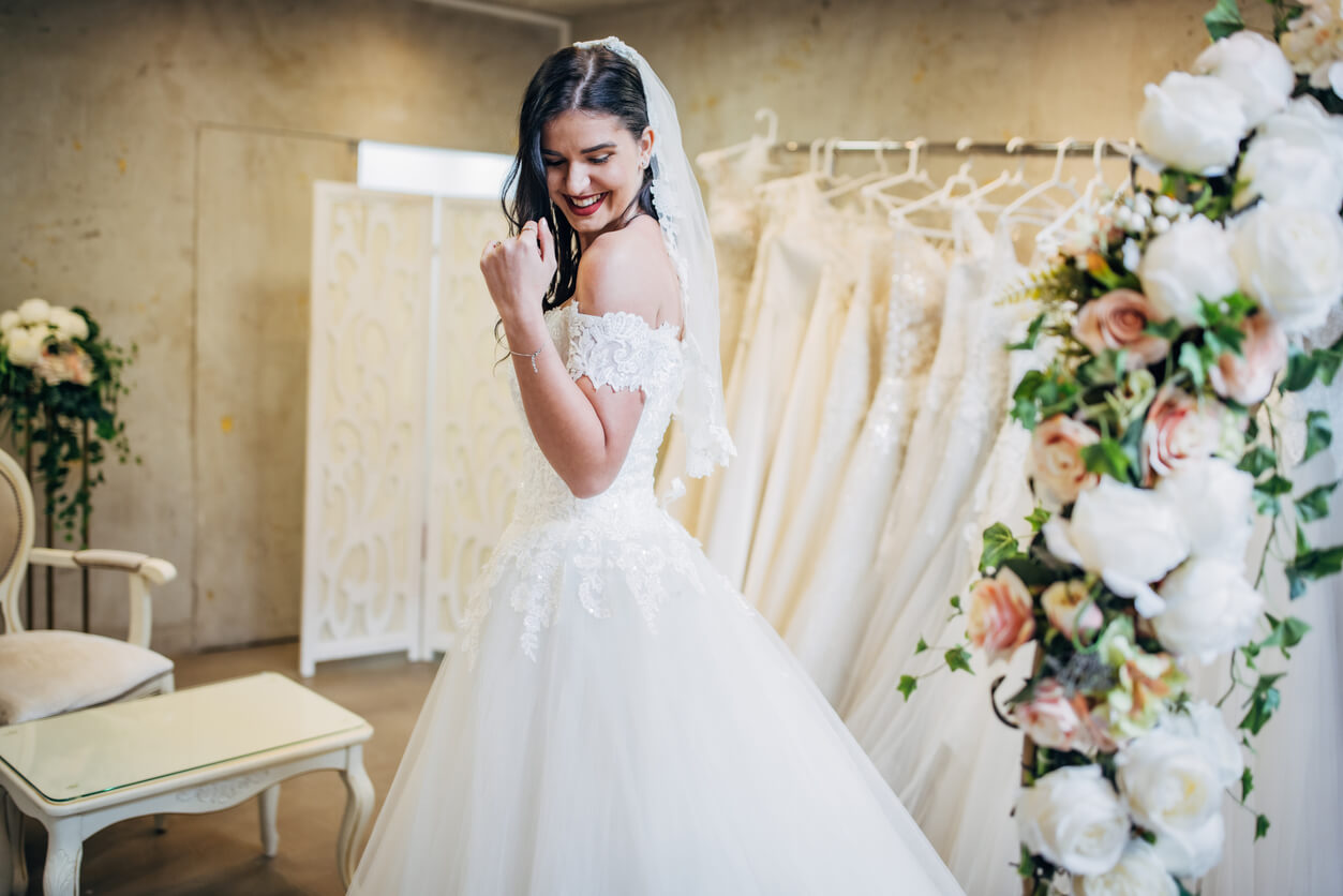 happy bride-to-be trying on a wedding gown and veil