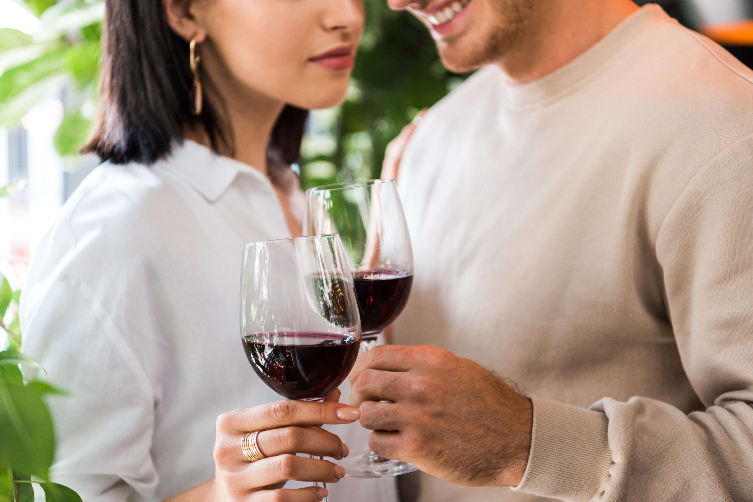 happy couple dressed in white and beige on a valentines day date with red wine